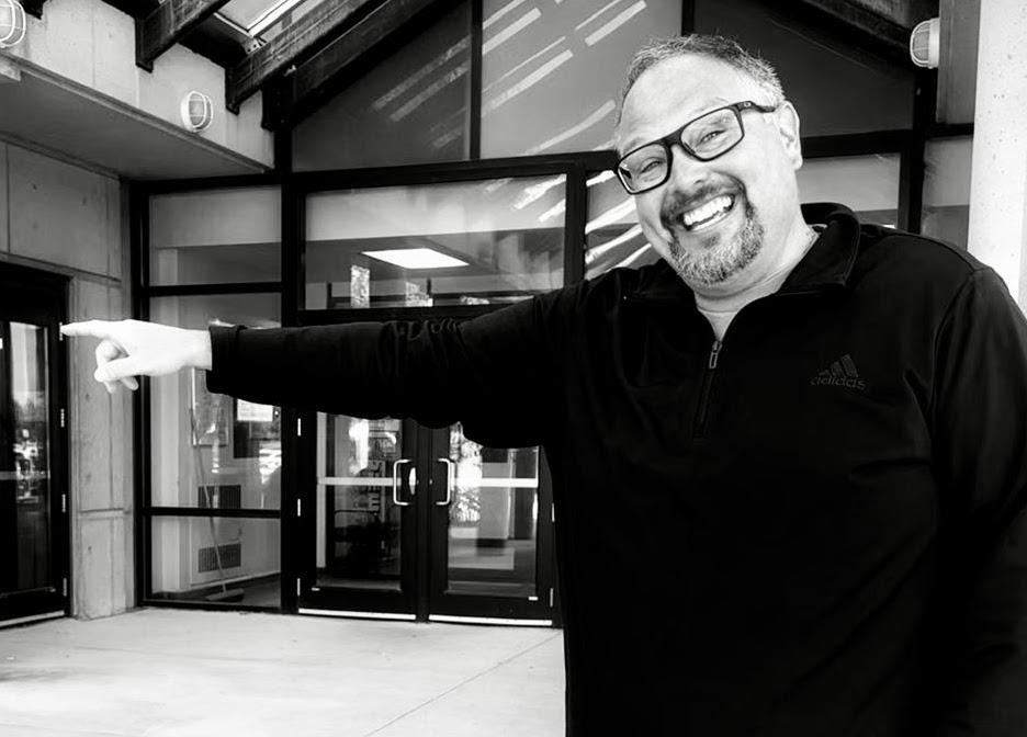 man holds arm outstretched pointing left