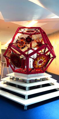 red 3D pentagon art installation on top of a white stair pedestal