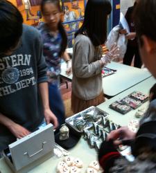 Students running transactions at a sushi sale